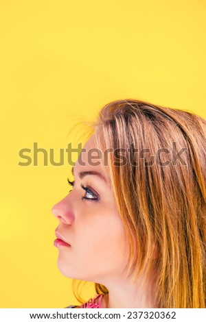 portrait of a young beautiful girl who looks in the direction on a yellow background