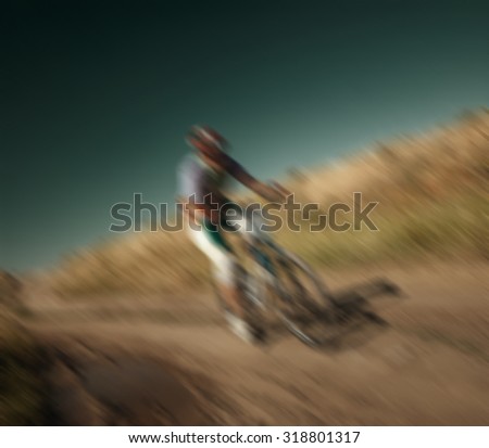 blurred background, racing cyclist rides on rough terrain