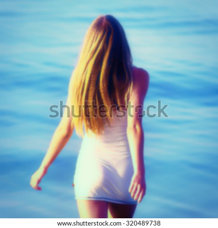 blurred background, girl goes to sea