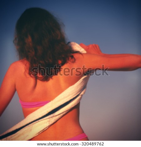 blurred background, a girl in a bathing suit doing a back massage towel