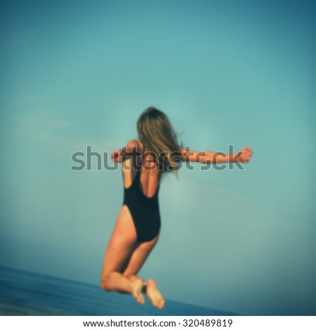 blurred background, a girl in a bathing suit jumped over the sea