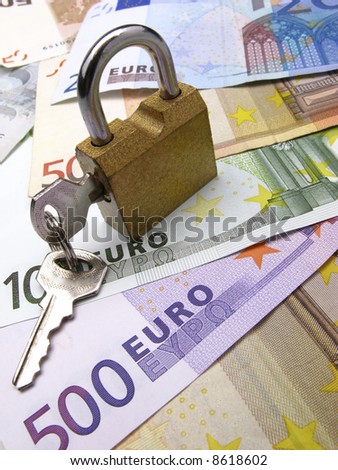 closed padlock with keys on  background euro and dollar banknotes, close up