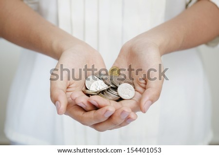Female hand holding singapore coin