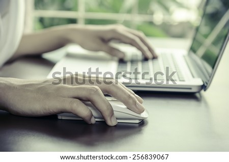 Woman using a mouse working on the computer
