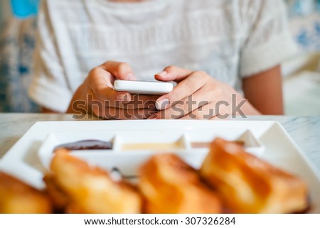 front view of woman using smart phone on the table
