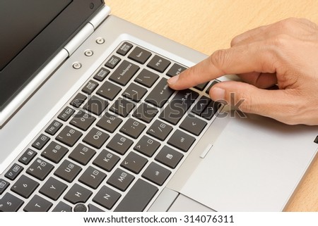 closeup male hand typing on laptop keyboard