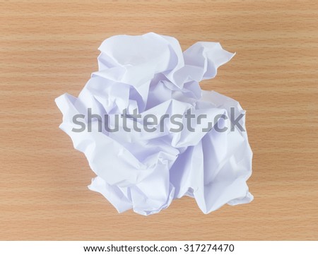 crumpled paper ball on wooden background