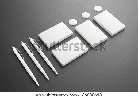 Blank Stationery / Corporate ID Set on dark background. Consist of Business cards, pens and buttons.