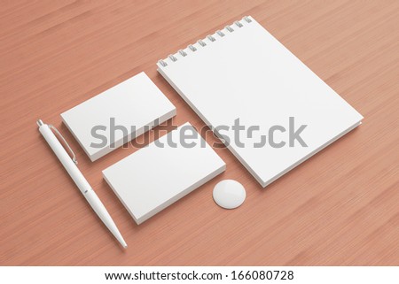 Blank Stationery / Corporate ID Set on wooden background . Consist of Business cards, pens, button and memobook