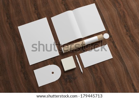 Blank stationery on wooden background. Consist of folder, magazine, envelope, notes, disk, tubus.
