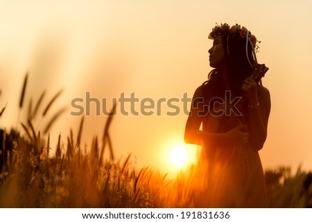 Beautiful asian women with ukulele in grass field , sunset of summer