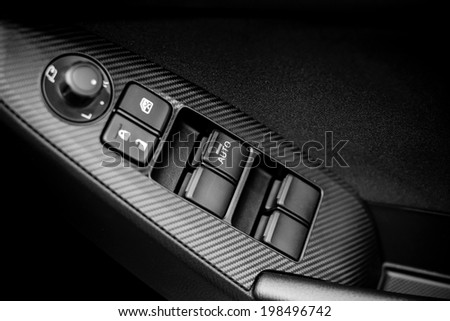 Window and mirror control panel on driver\'s door, detail of modern car , black and white