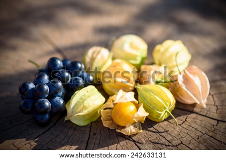 Cape gooseberry and grapes  wooden table