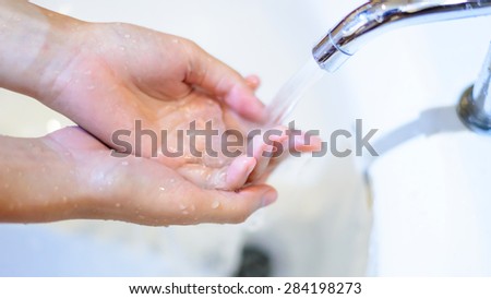 Washing hands under flowing tap water