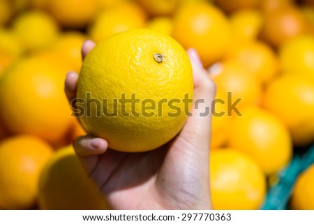 Female Hand pick up Orange in market