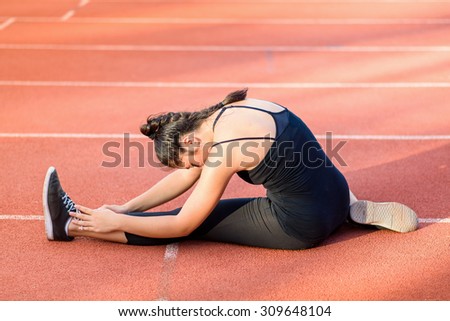 Young woman taking exercise outdoors on running track