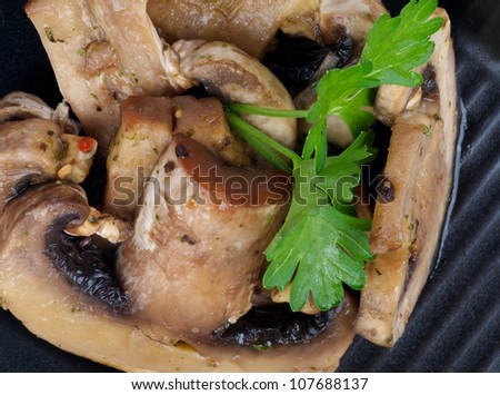 Stack of Cooked Mushrooms with Parsley on black plate