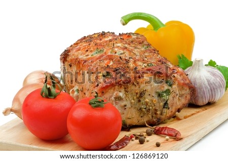 Roasted Loin Pork and Various Vegetables with Parsley, Tomato , Garlic, Onions, Bell Pepper and Spices closeup on Cutting Board