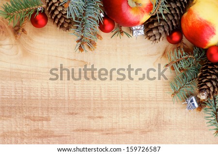 Corner Border of Spruce Branch, Red Baubles, Fir Cones and Delicious Apples closeup on Wooden background. Horizontal View