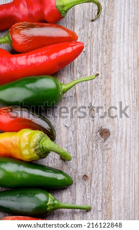Frame of Red and Green Habanero and Jalapeno Chili Peppers isolated on Rustic Wooden background