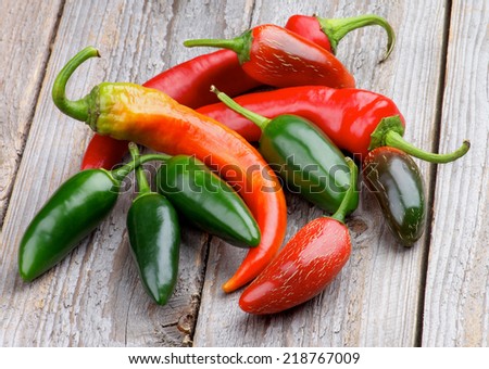 Arrangement of Red and Green Habanero and Jalapeno Chili Peppers isolated on Rustic Wooden background