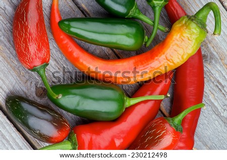 Heap of Red and Green Habanero and Jalapeno Chili Peppers isolated on Rustic Wooden background. Top View