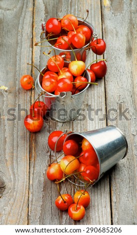 Sweet Maraschino Cherries in Three Tin Buckets on Rustic Wooden background