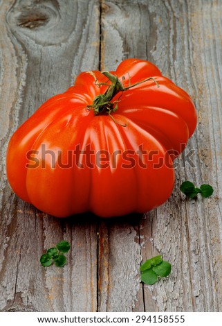 Big Raw Ripe Beefsteak Tomato closeup on Rustic Wooden background