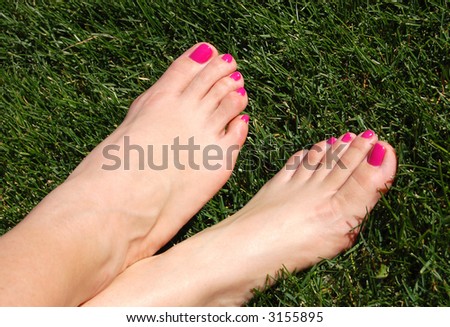 Cute feet with a fresh pedicure in the grass