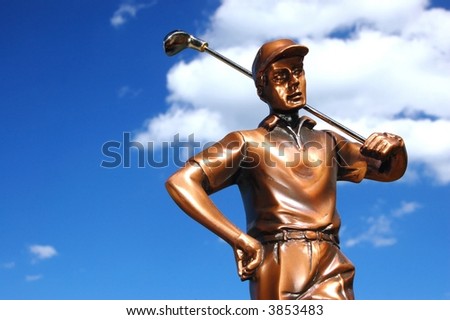 Bronze golf trophy set against the blue sky