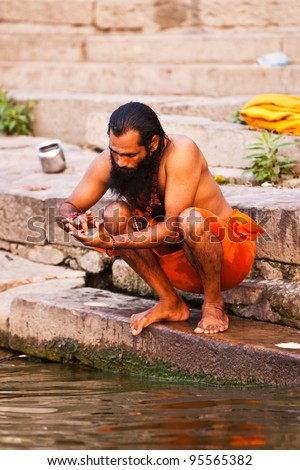VARANASI, INDIA - APRIL 25: Unidentified man taking ritual bath in the river Ganga on April 25, 2011 in the holy city of Varanasi, India. The holy ritual bath is held every day.