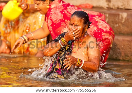 VARANASI, INDIA - APRIL 25: Unidentified woman washes her face in the river Ganga on April 25, 2011 in the holy city of Varanasi, India. The holy ritual of washing is held every day.