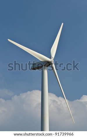Wind turbine propeller blades against blue sky