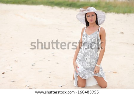 young woman in a white dress on a background of tall grass