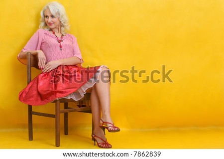 bright woman in red on the old wooden chair