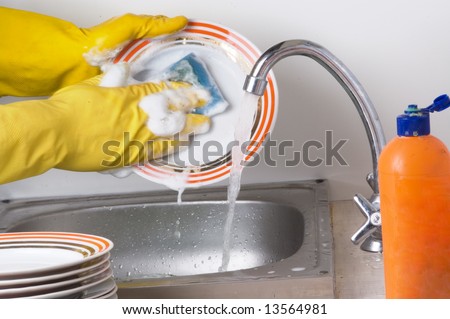Man hands, washing the dishes at the kitchen