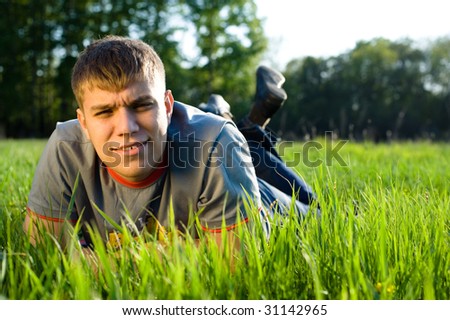 Young man lying down of grass. Copy space