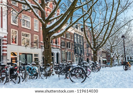 Amsterdam town square in winter with snow covered bicycles
