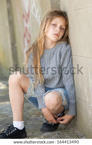 Sad Little Girl Sitting Against The Wall Stock Photo 164413490 ...