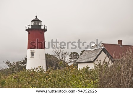 Cape Cod\'s colorful Nauset Light stands amid the foliage of  Eastham, Massachusetts
