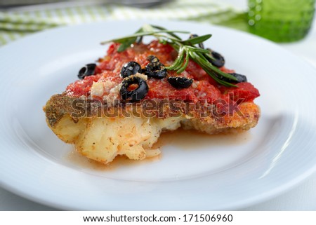 Baked cod under tomato sauce with olives and rosemary