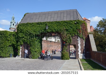 KRAKOW, POLAND - SEPTEMBER 15, 2013: Tourists under the Bernardine Gate of Wawel royal castle. Built in the XVI century, now the castle is the museum and the main attraction of the city