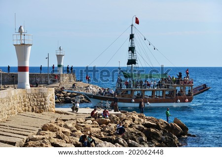 ANTALYA, TURKEY - MARCH 26, 2014: Trip boat with tourists entering the port. Boat trip is lovely leisure activity for thousands of tourists