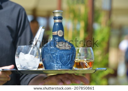 TSELEEVO, MOSCOW REGION, RUSSIA - JULY 26, 2014: Waiter offers the whiskey Royal Salute to the guests of the British Polo Day. This brand of Scotch whisky produced by Chivas Brothers