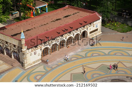 KHARKOV, UKRAINE - JUNE 10, 2014: People resting in front of the children autodrome in the Central park named after M. Gorky. Autodrome is one of the three most visited attractions in the park