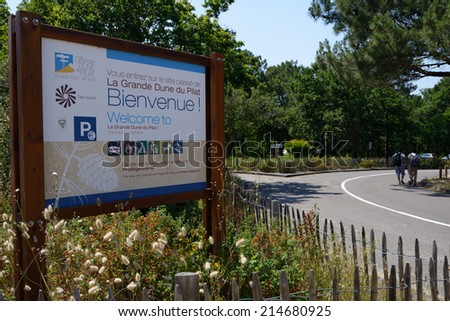 PILAT, FRANCE - JUNE 27, 2013: Welcome board and tourist going to the dune of Pilat. This dune is the biggest one in Europe, and it still grows