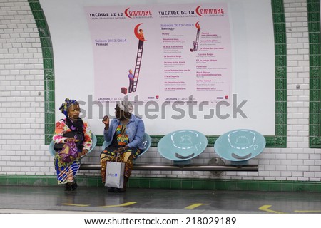 PARIS, FRANCE - SEPTEMBER 13, 2013: Two women wait a train in the Paris metro. It\'s the second busiest metro system in Europe, after Moscow