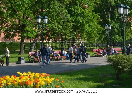 MOSCOW, RUSSIA - MAY 17, 2014: People walking in the Alexander Garden under the Kremlin walls. Founded in 1812, the garden is the favorite place to walk for tourists and locals