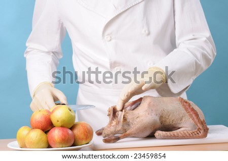 Chef cooking goose with apples