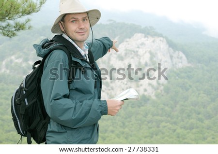 Hiker with map pointing direction while out trekking